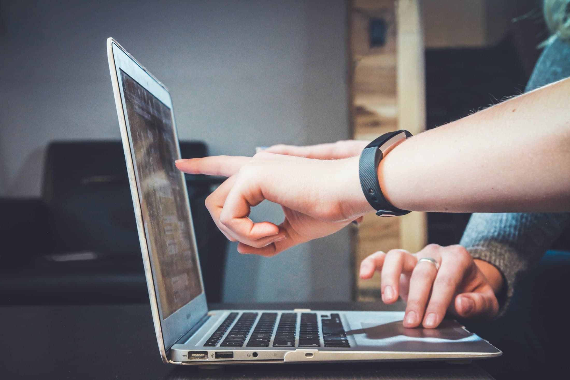 A hand pointing at a Tableau dashboard on a laptop screen during a working session